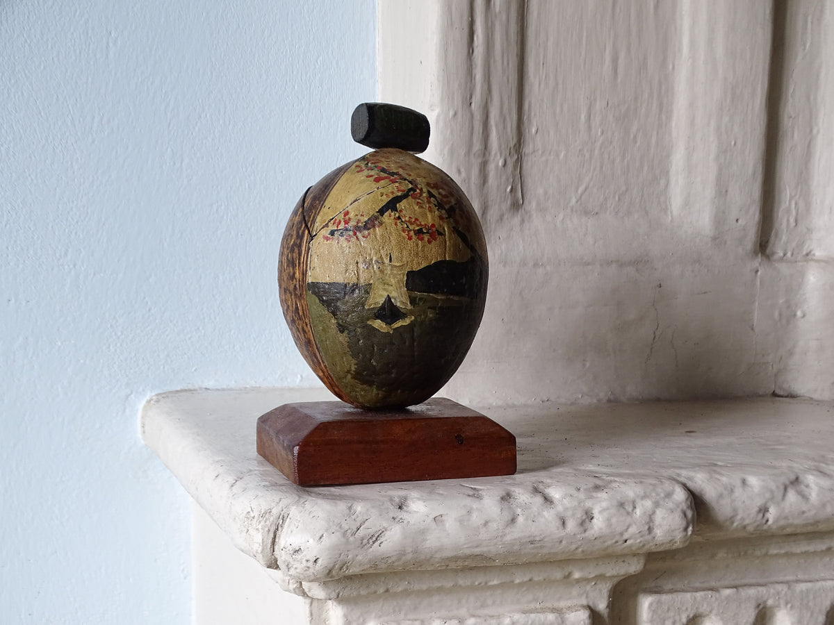 Vintage coconut souvenir trinket box, pictured on a country house fireplace