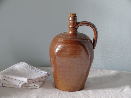 French vintage stoneware pitcher with brown salt glaze, pictured with antique linen