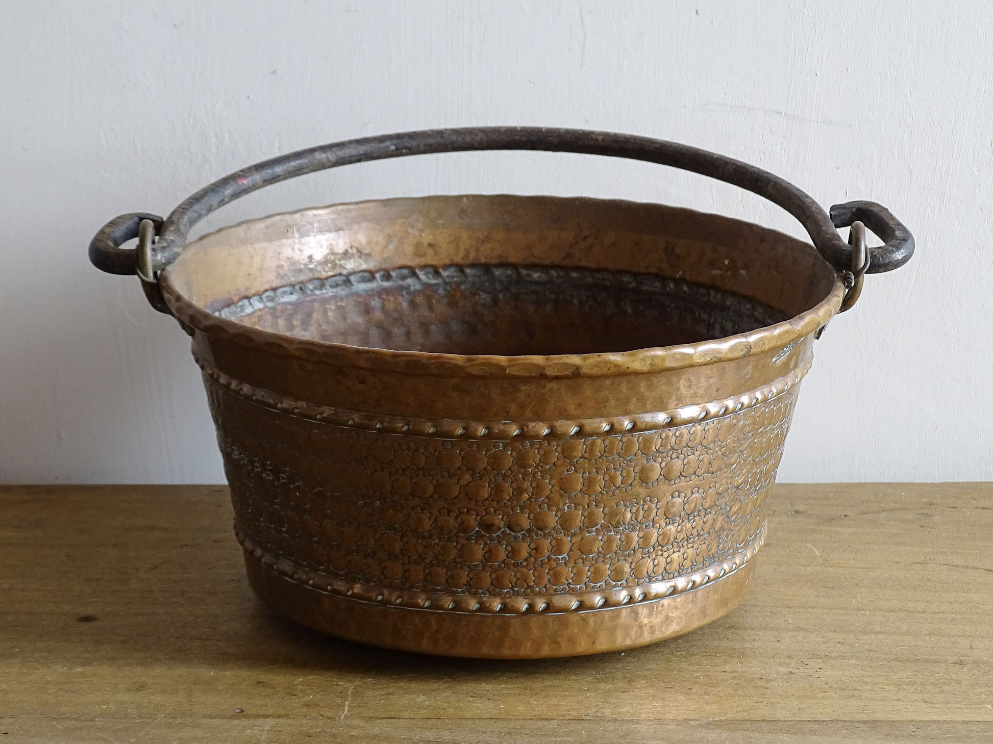 Small vintage copper cauldron with a hammered effect. It has a wrought iron handle and delicate brass detailing. Small copper cauldron or planter.