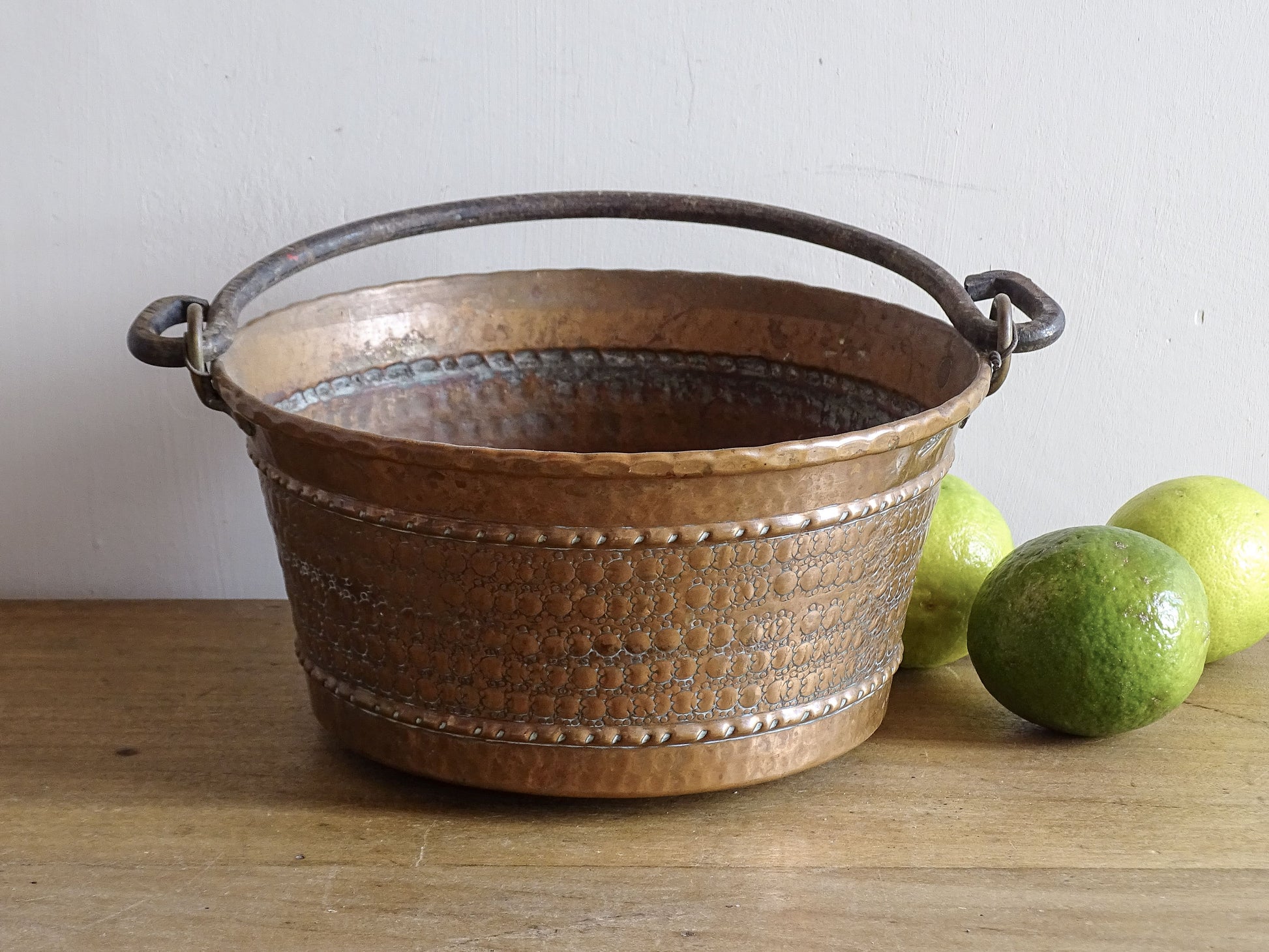 Small vintage copper cauldron with a hammered effect. It has a wrought iron handle and delicate brass detailing. Small copper cauldron or planter.