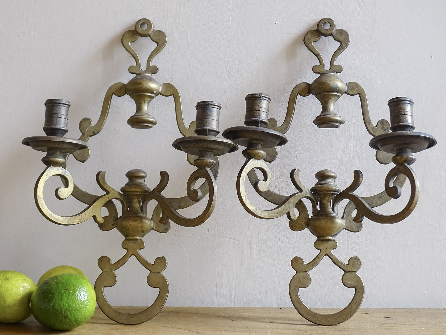 Pair of vintage brass wall sconces on a plain background