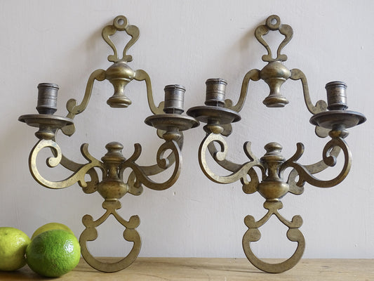 Pair of vintage brass wall sconces on a plain background