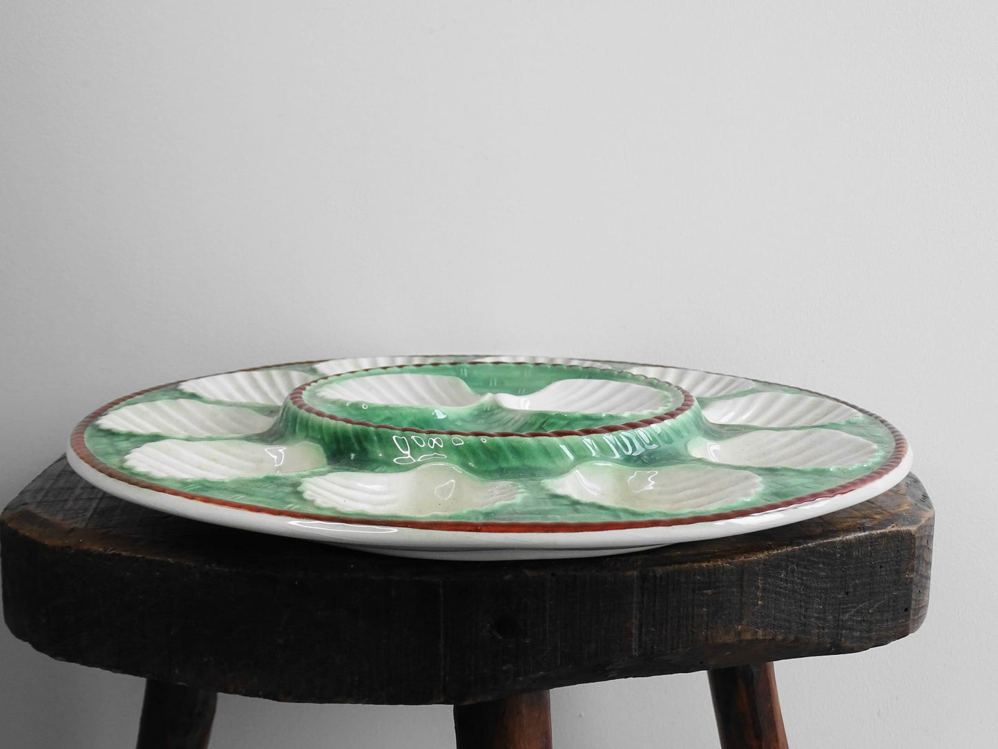 Vintage French barbotine oyster serving plate with space for twelve oysters, dating to around the 1930s. It has a green, basketweave design with a brown edge