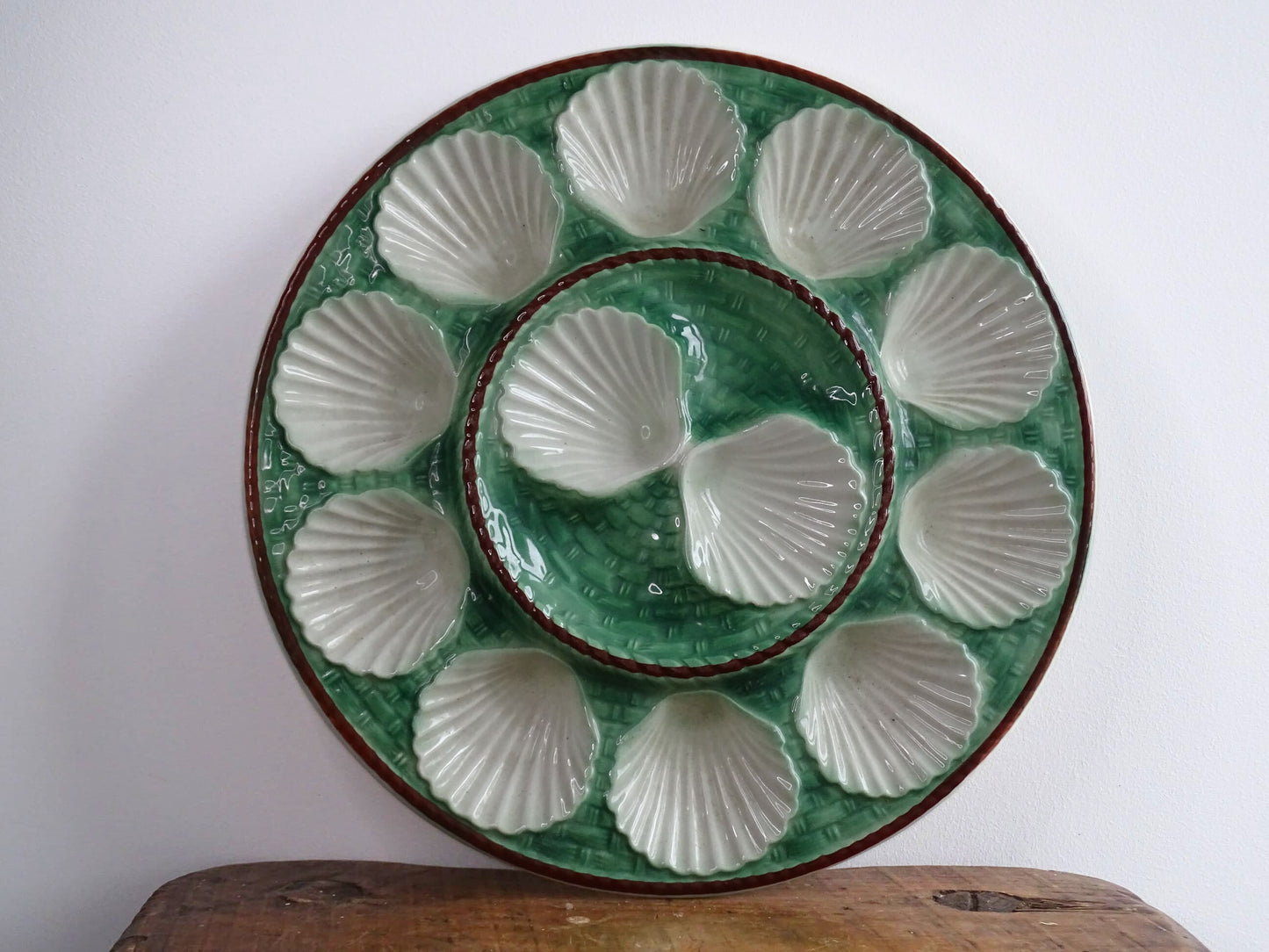 Vintage French barbotine oyster serving plate with space for twelve oysters, dating to around the 1930s. It has a green, basketweave design with a brown edge