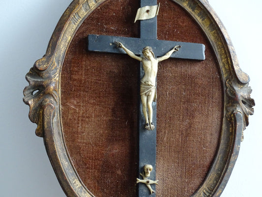 French antique framed crucifix with a gold wood oval frame and a brown velvet background