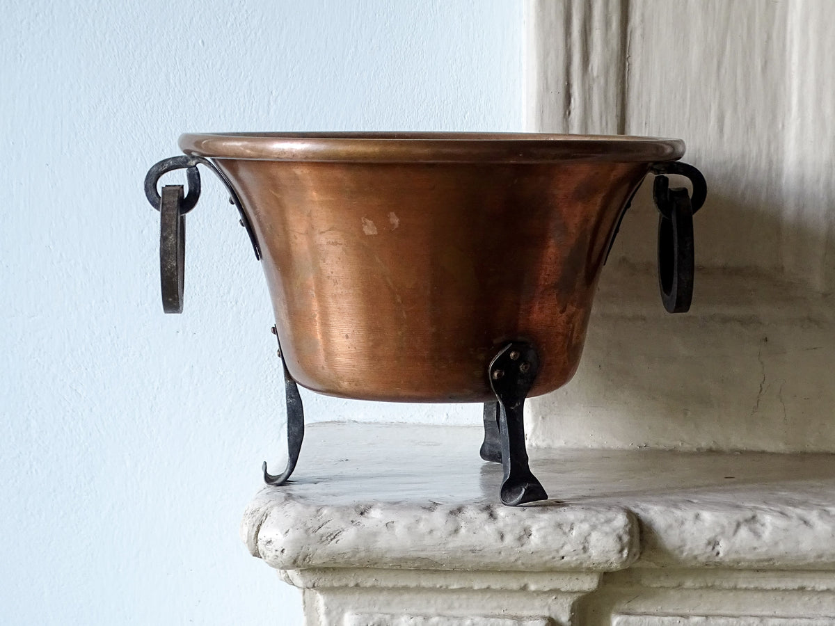 French antique copper planter with wrought iron handles and feet, pictured on a country house fireplace