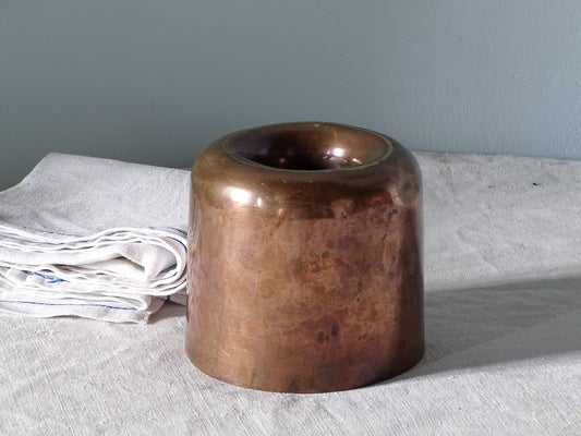French antique copper mould for the kitchen, pictured with linen in front of a pale blue wall