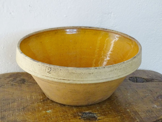 Rustic French antique ceramic mixing bowl with an orange glaze to the interior. Terracotta pottery bowl for a French country farmhouse kitchen.