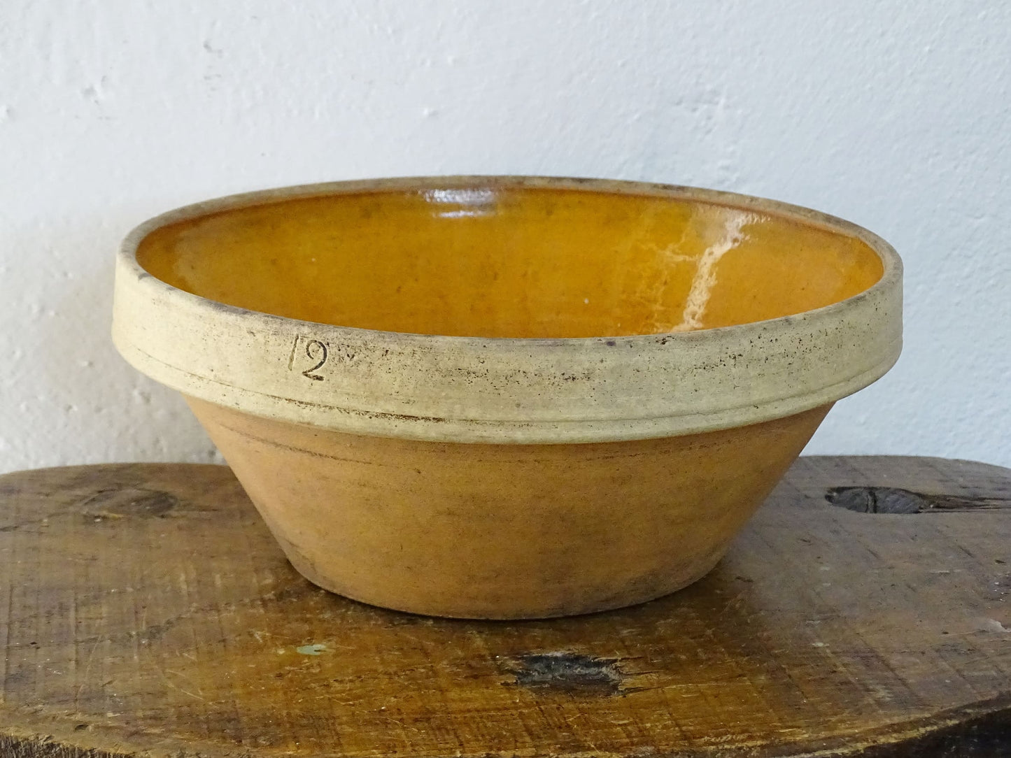 Rustic French antique ceramic mixing bowl with an orange glaze to the interior. Terracotta pottery bowl for a French country farmhouse kitchen.