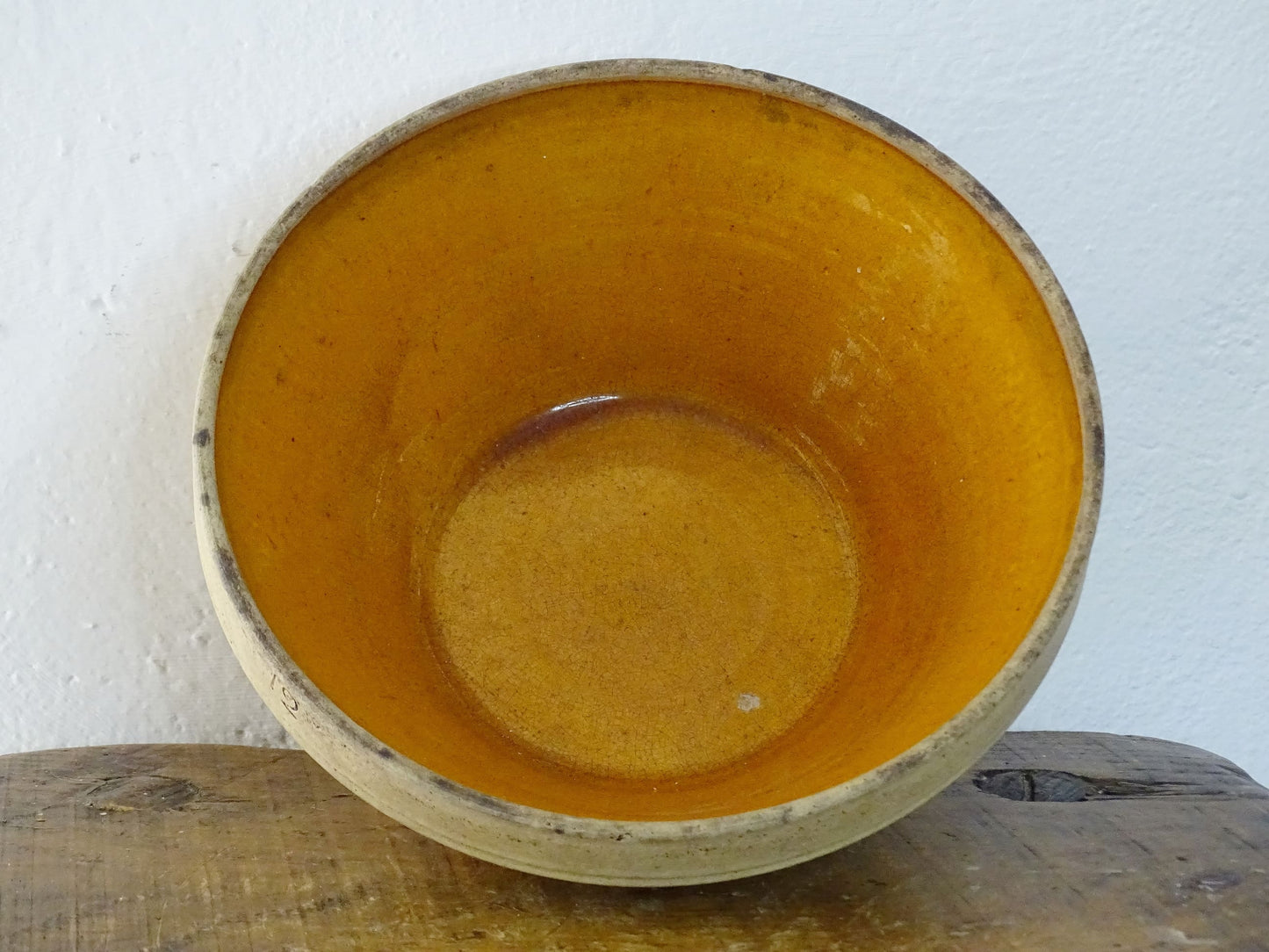 Rustic French antique ceramic mixing bowl with an orange glaze to the interior. Terracotta pottery bowl for a French country farmhouse kitchen.