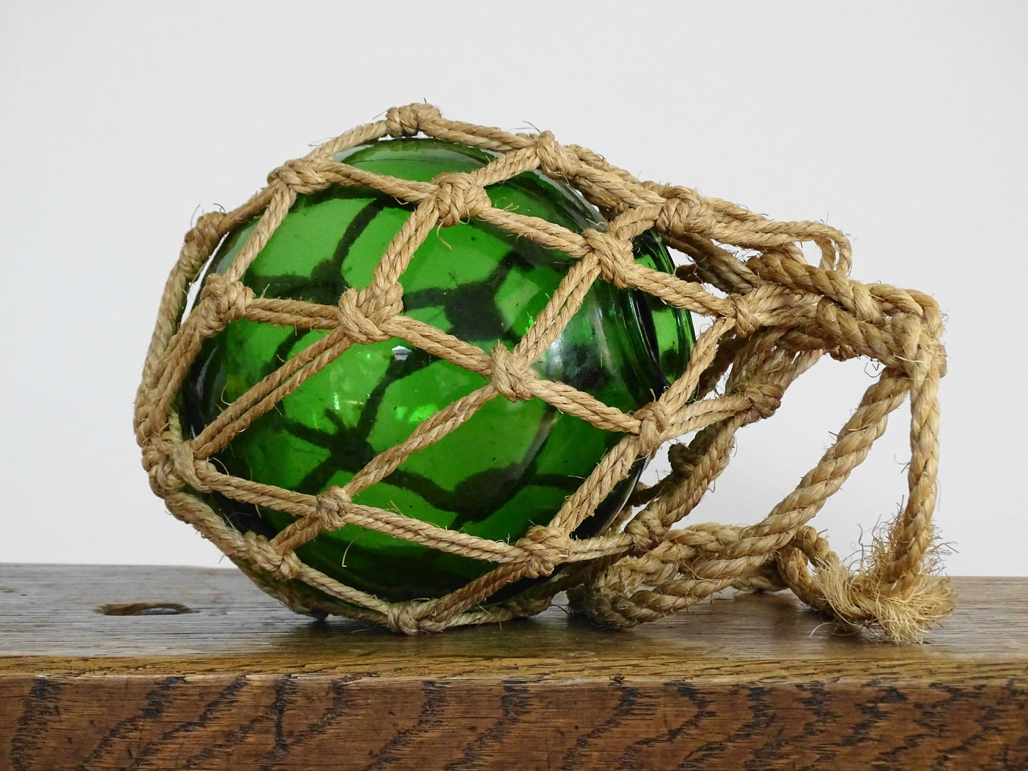 French vintage green glass fishing buoy or glass sphere in a natural colour rope