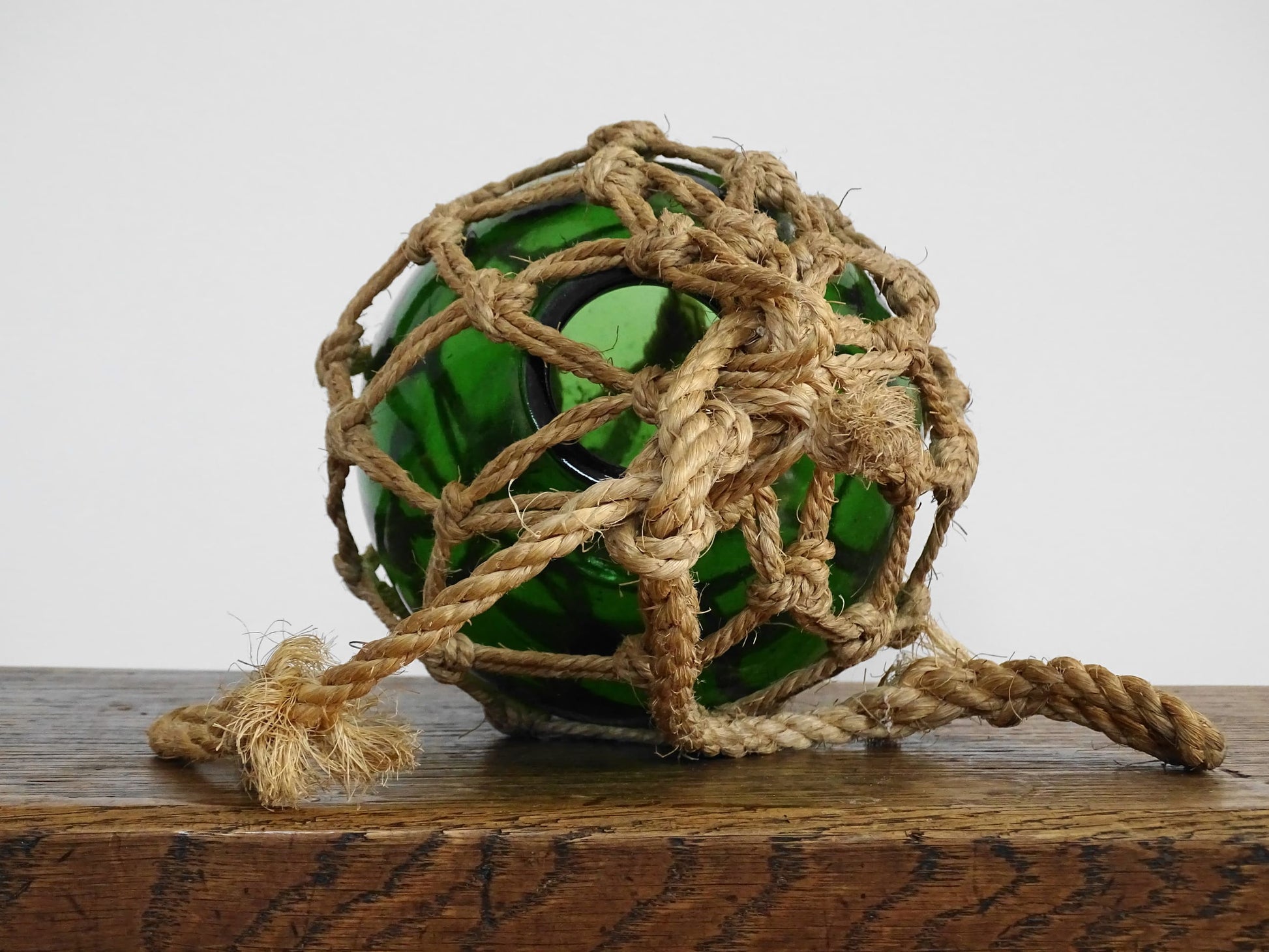 French vintage green glass fishing buoy or glass sphere in a natural colour rope