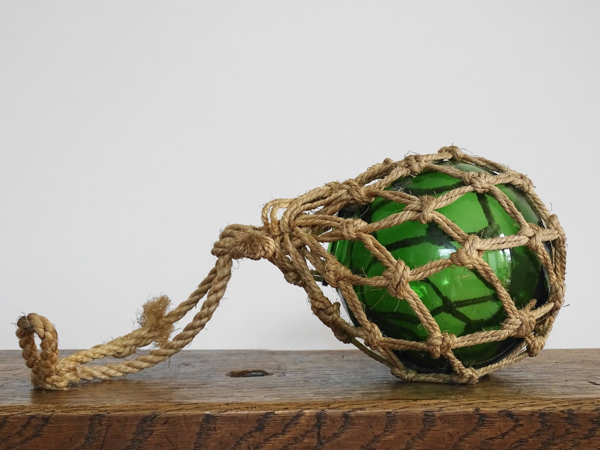 French vintage green glass fishing buoy or glass sphere in a natural colour rope