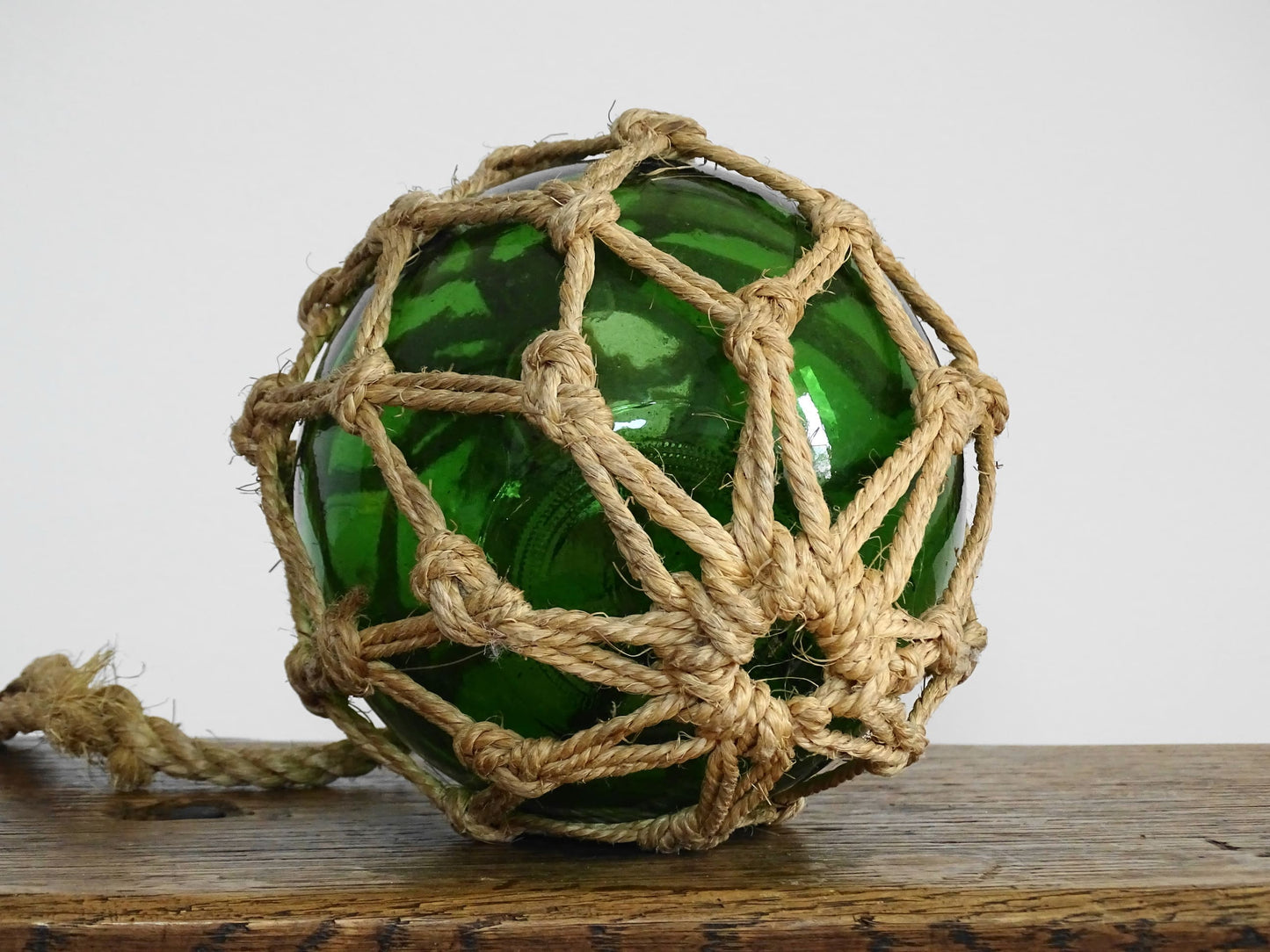 French vintage green glass fishing buoy or glass sphere in a natural colour rope