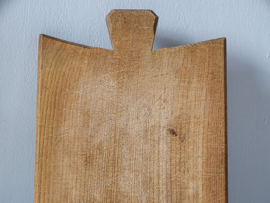 Close-up of vintage French cutting board surface showing numerous fine knife marks, scratches and naturally aged wood.