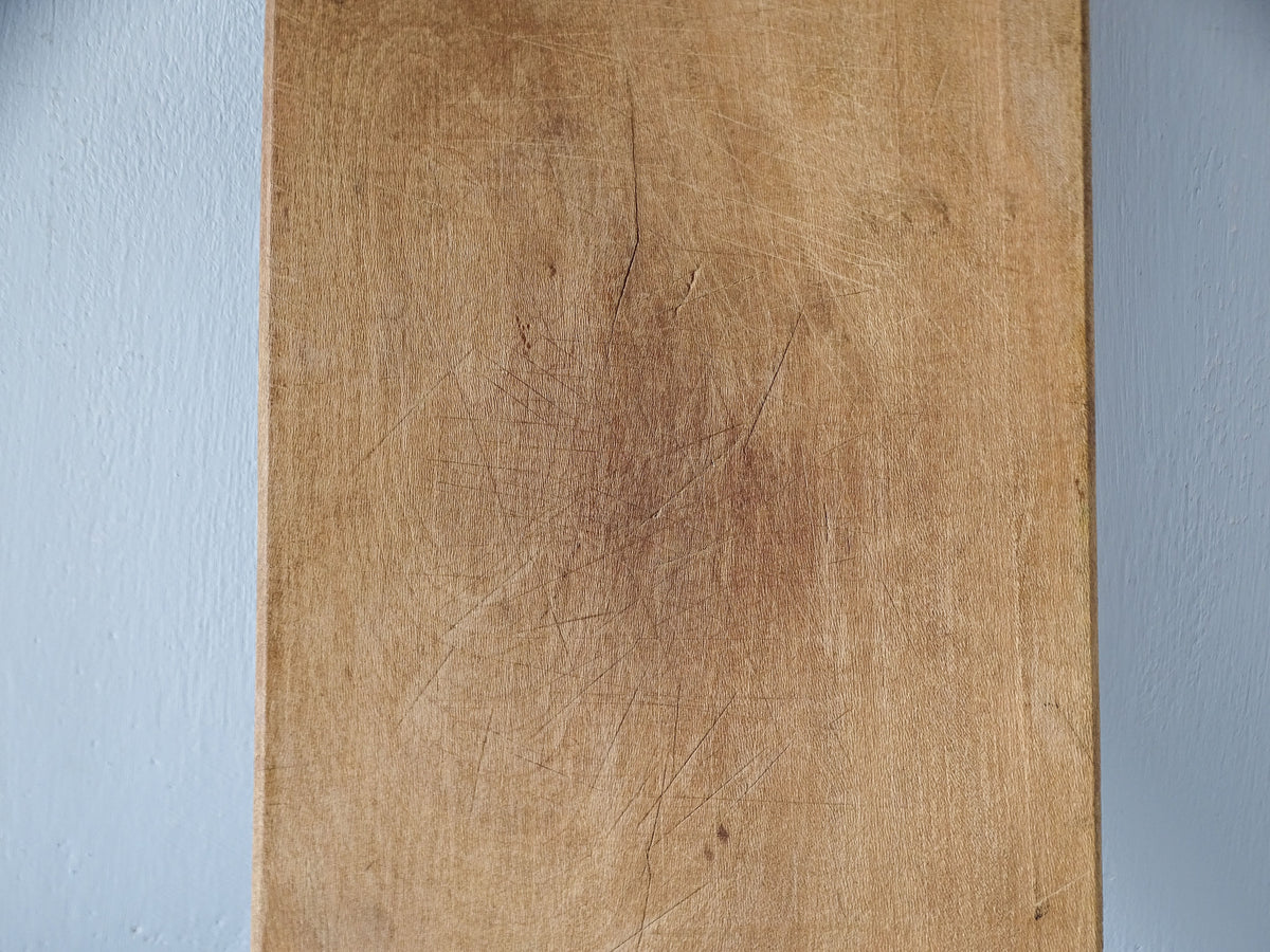 Close-up of vintage French chopping board showing its naturally aged wooden surface, fine knife marks and darker areas of wear.