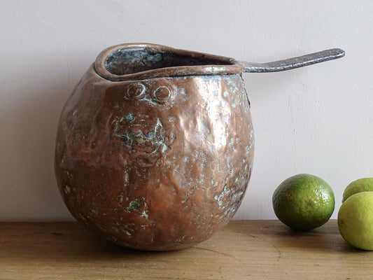 French antique copper zabaglione pan with a curved base, rustic dents, and a rich patina, ideal as a copper kitchen accent in a French farmhouse kitchen, displayed hanging or on a shelf alongside vintage cookware.