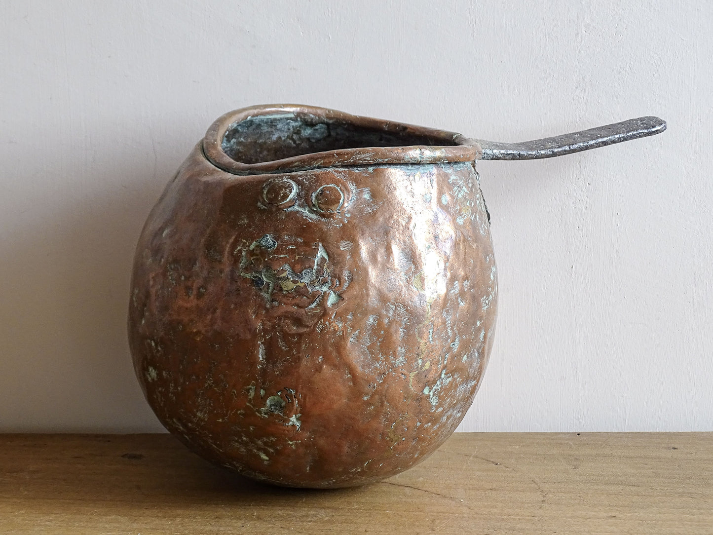 French antique copper zabaglione pan with a curved base, rustic dents, and a rich patina, ideal as a copper kitchen accent in a French farmhouse kitchen, displayed hanging or on a shelf alongside vintage cookware.