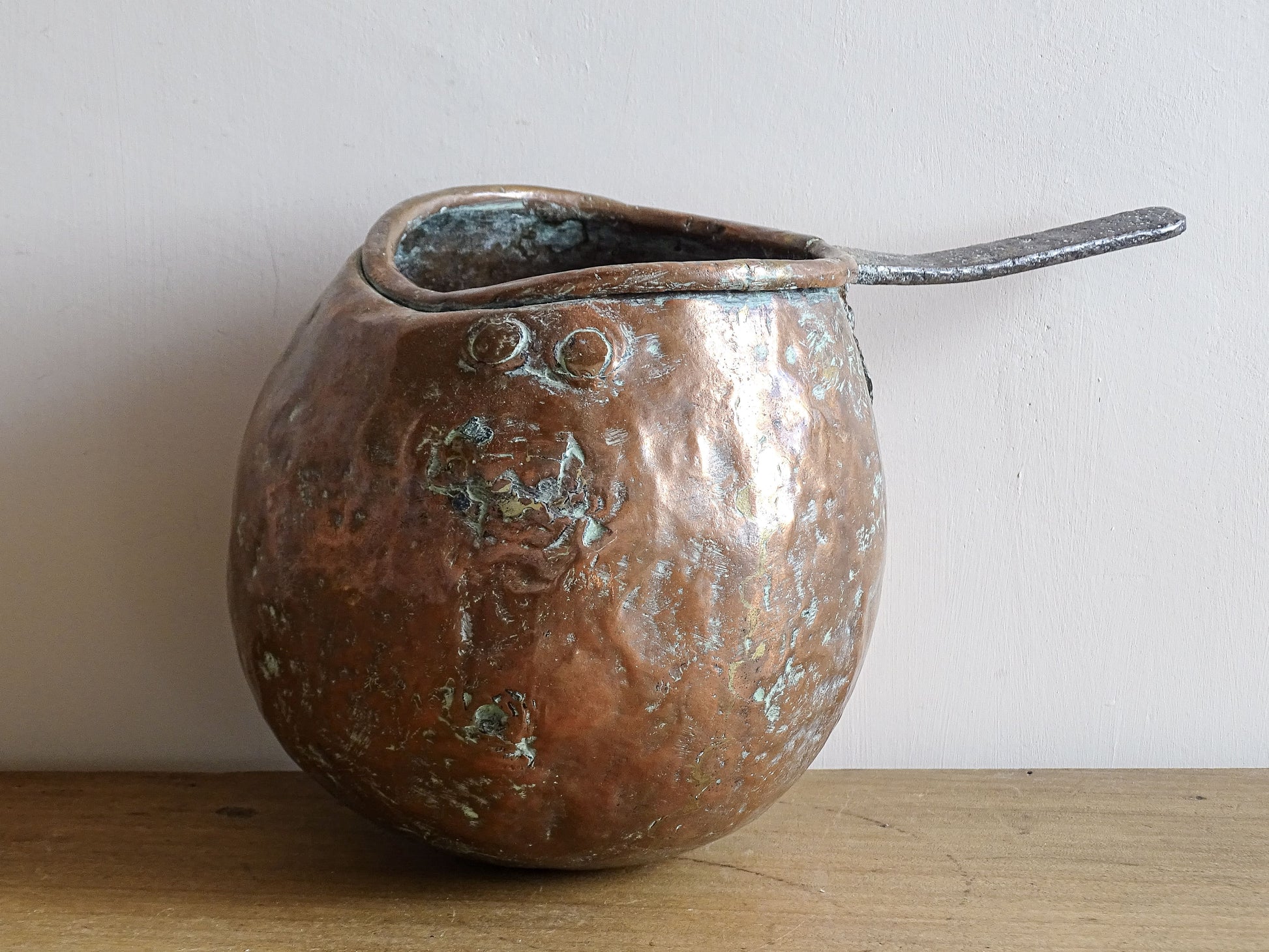 French antique copper zabaglione pan with a curved base, rustic dents, and a rich patina, ideal as a copper kitchen accent in a French farmhouse kitchen, displayed hanging or on a shelf alongside vintage cookware.
