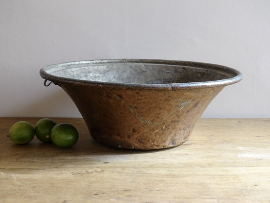 Large French antique copper bowl, it has an aged exterior with a warm patina and a tinned copper interior. It has a flared shape and substantial size. French farmhouse aesthetic decor.