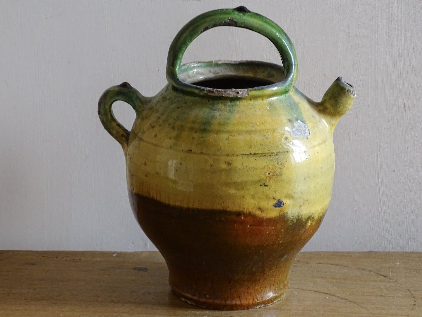French antique pottery pitcher or gargoulette with a yellow and green glaze 