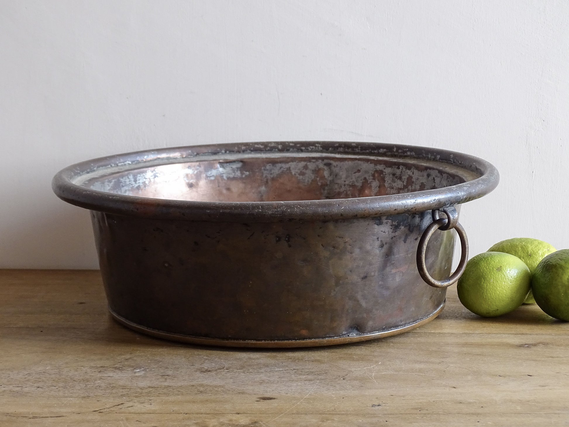 French antique copper mixing bowl with rolled top and handle. Copper bowl with timeworn appearance for a French country farmhouse kitchen.