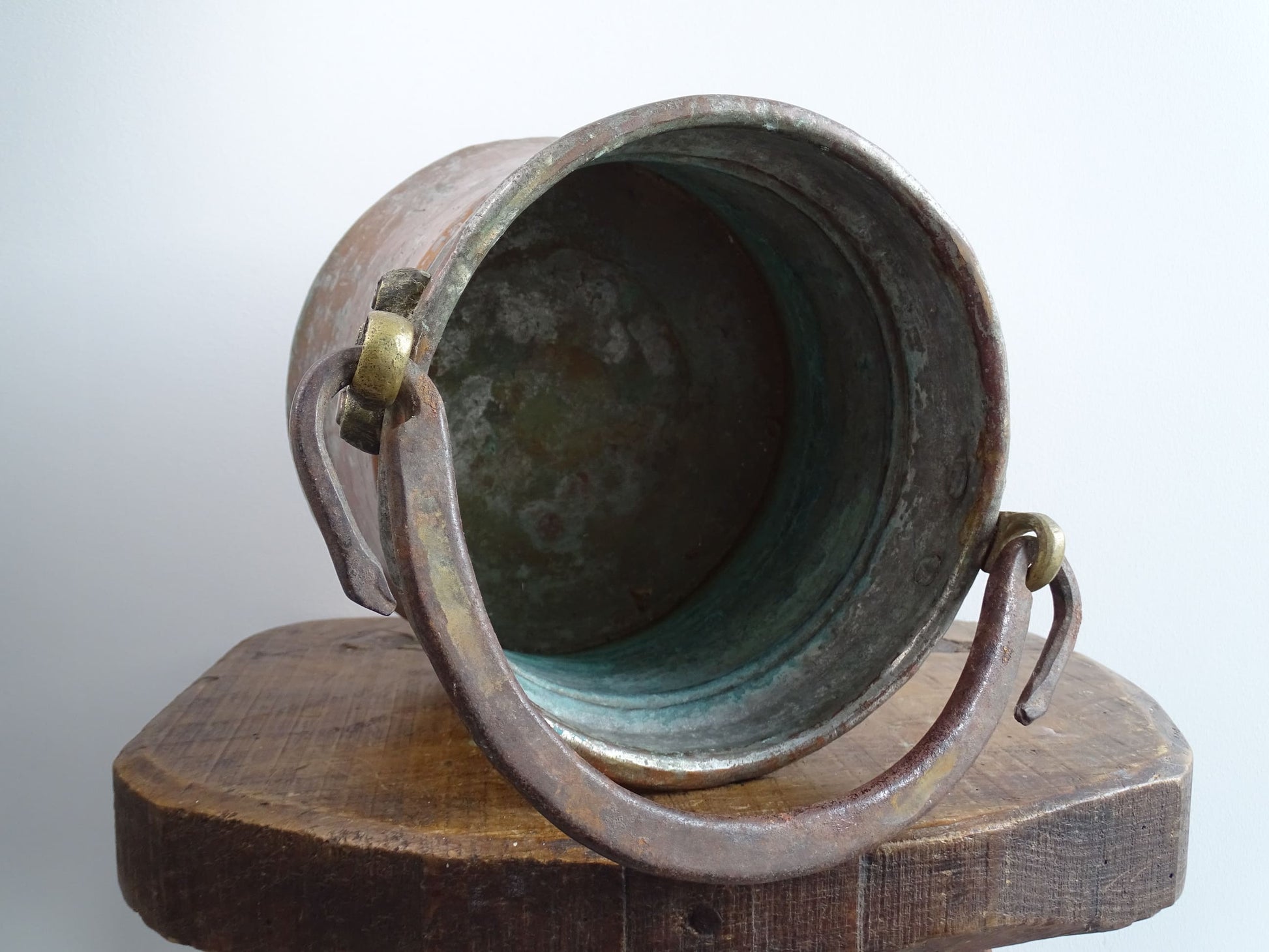 French antique tinned copper cauldron with brass detailing. A small antique copper cauldron with patina. A planter or utensil holder in a French country farmhouse kitchen.