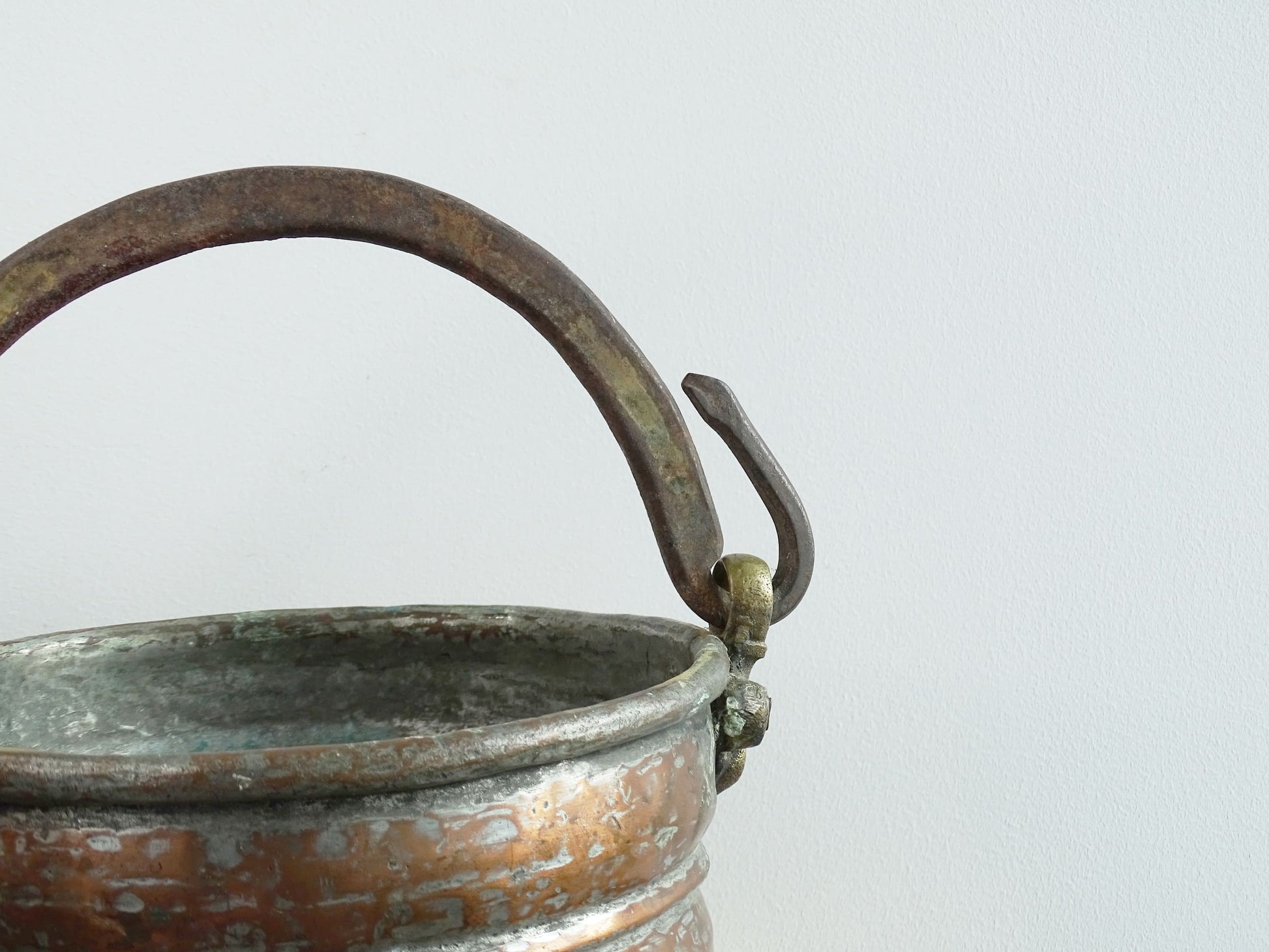 French antique tinned copper cauldron with brass detailing. A small antique copper cauldron with patina. A planter or utensil holder in a French country farmhouse kitchen.