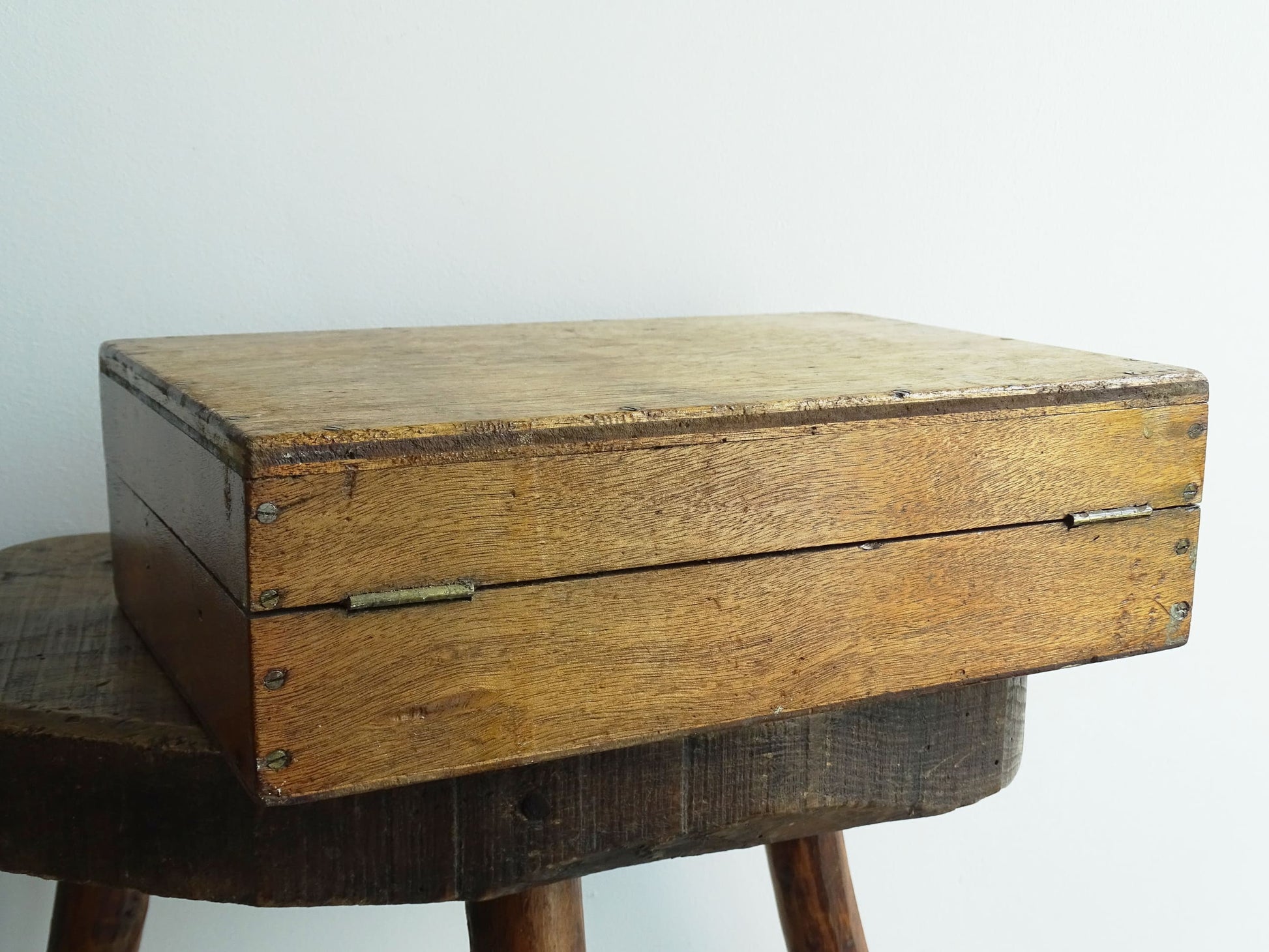 French antique paint box filled with paint brushes and painter’s tools. It has specks of paint and the outside of the wooden box has a “D” initial. The artist's box or painter's box has a rich patina.