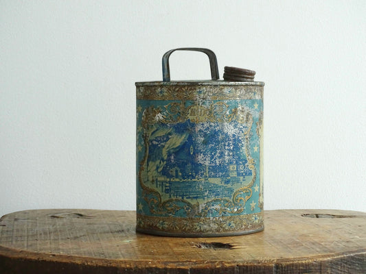 French antique Lourdes souvenir water flask in light blue, made from pewter, the top is decorated with stars, one side shows a view towards the cathedral (Sanctuaire de Notre-Dame de Lourdes), the other shows pilgrims in early 20th century dress attending mass at the Grotto of Massabielle. To the side is a depiction of the Virgin Mary. Flask for Lourdes holy water. Antique Lourdes souvenir religious decor.