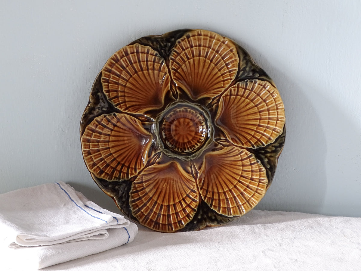 French vintage ceramic oyster plate with brown glaze, pictured with antique linen