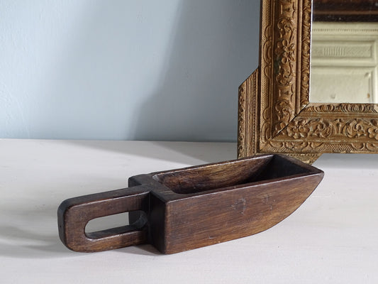 French antique wooden grain scoop with a loop handle in a dark wood, pictured with a gold mirror