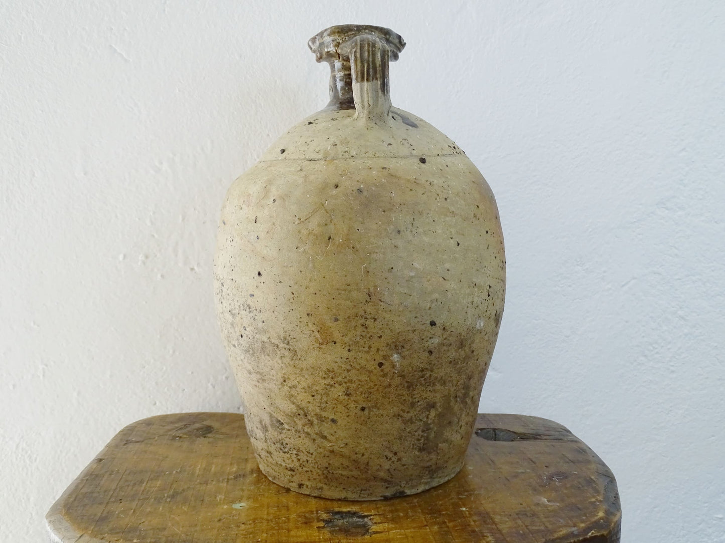 French antique pottery pitcher for a rustic farmhouse kitchen. Earthenware pottery pitcher with brown top, two handles and red-tone body