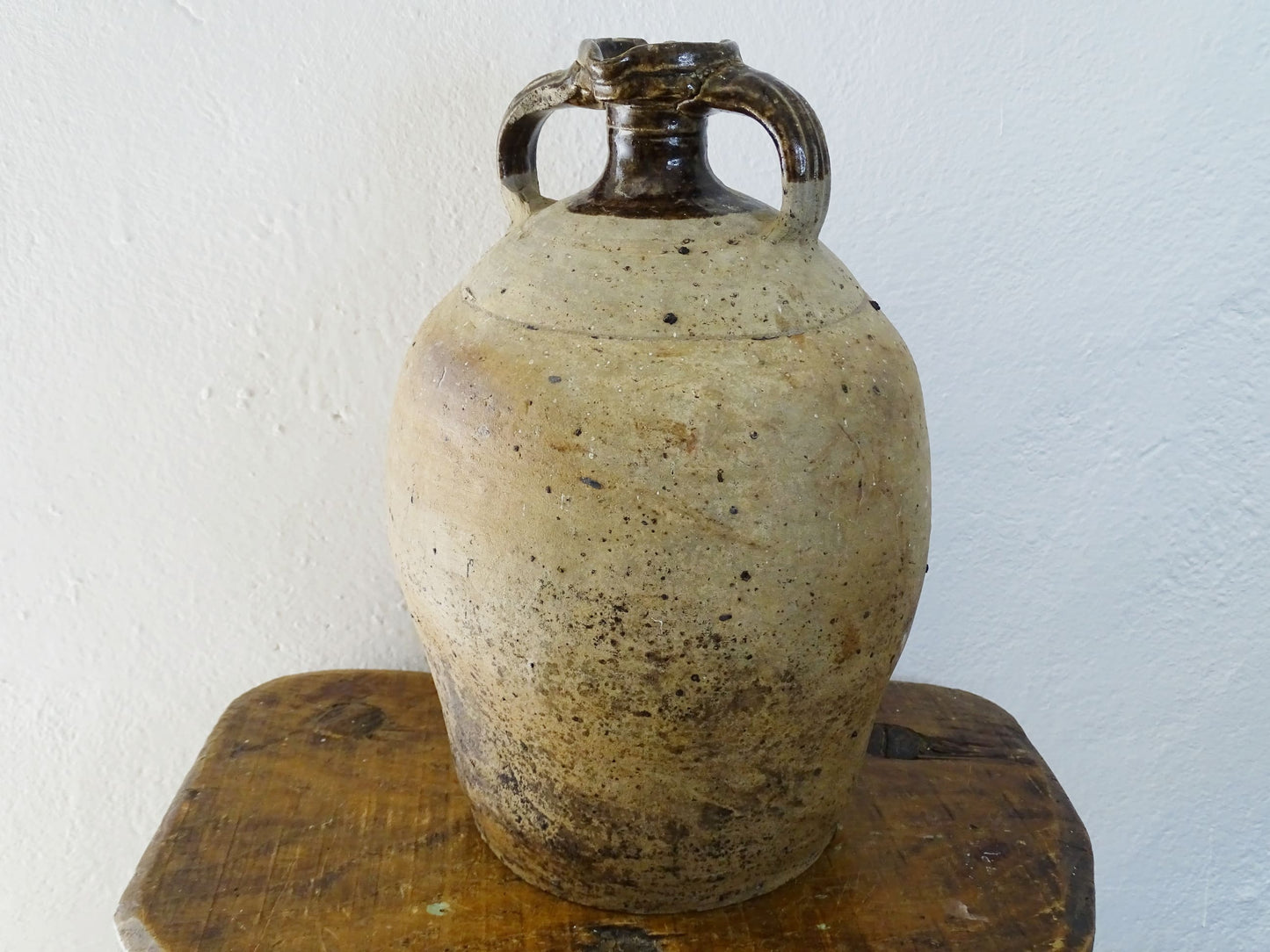 French antique pottery pitcher for a rustic farmhouse kitchen. Earthenware pottery pitcher with brown top, two handles and red-tone body