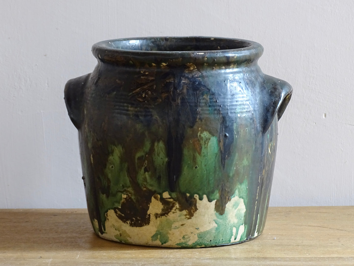 French antique stoneware pot with a green drip paint over earthy base tones. Confit pot for rustic farmhouse decor.