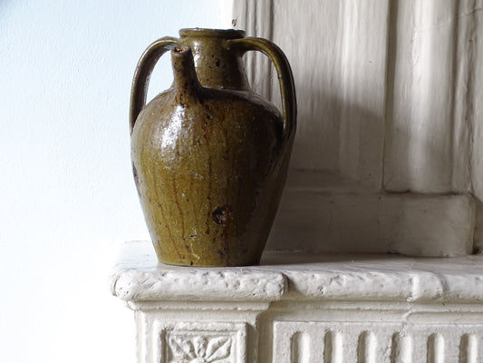 French antique pottery walnut oil jug with a green glaze on a country house fireplace