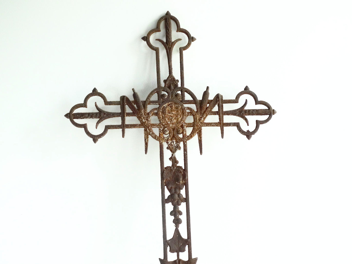 French antique cast iron field cross. Aged and rusted antique pilgrim cross decorated with grapes and vines.