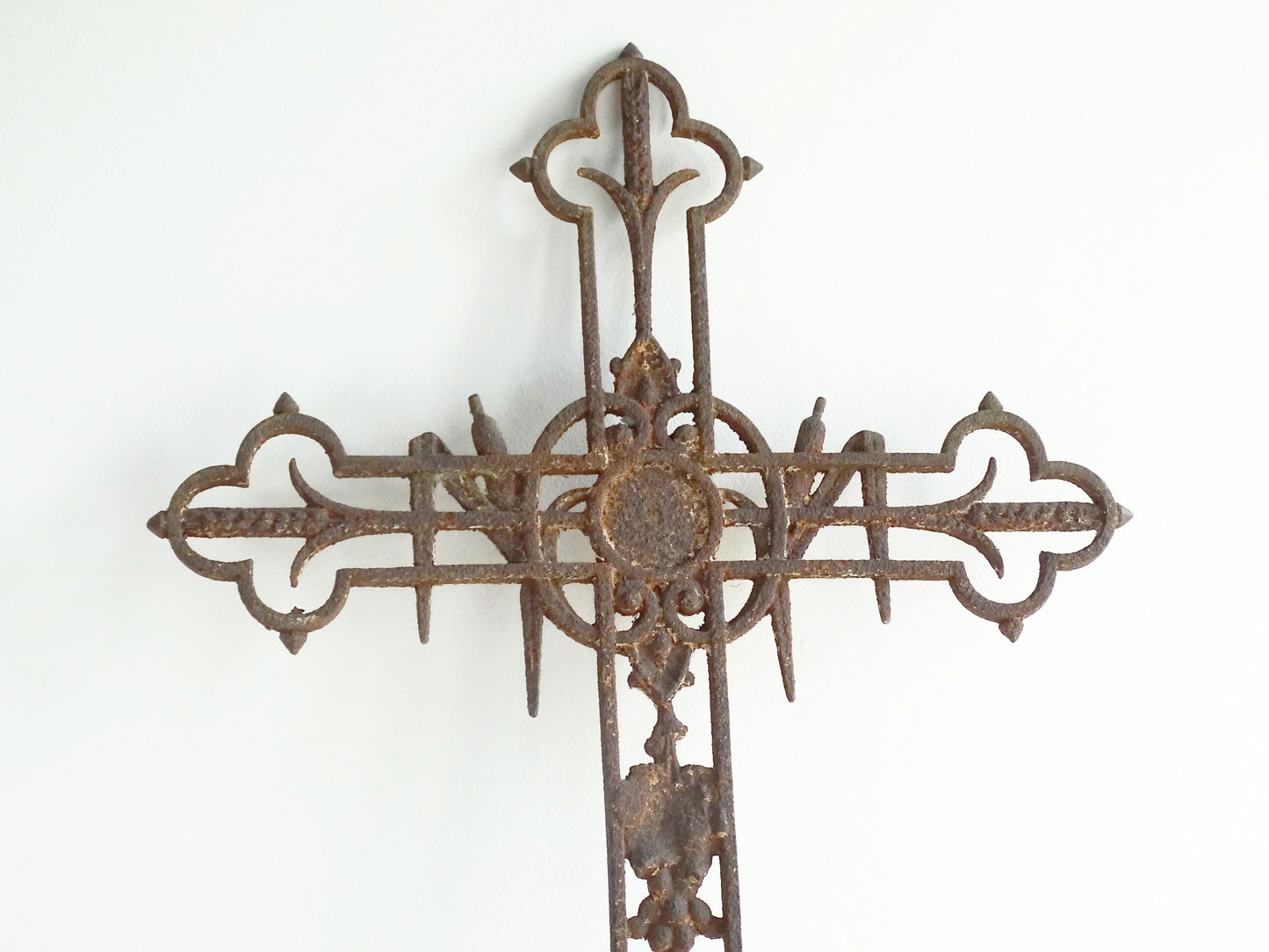 French antique cast iron field cross. Aged and rusted antique pilgrim cross decorated with grapes and vines.