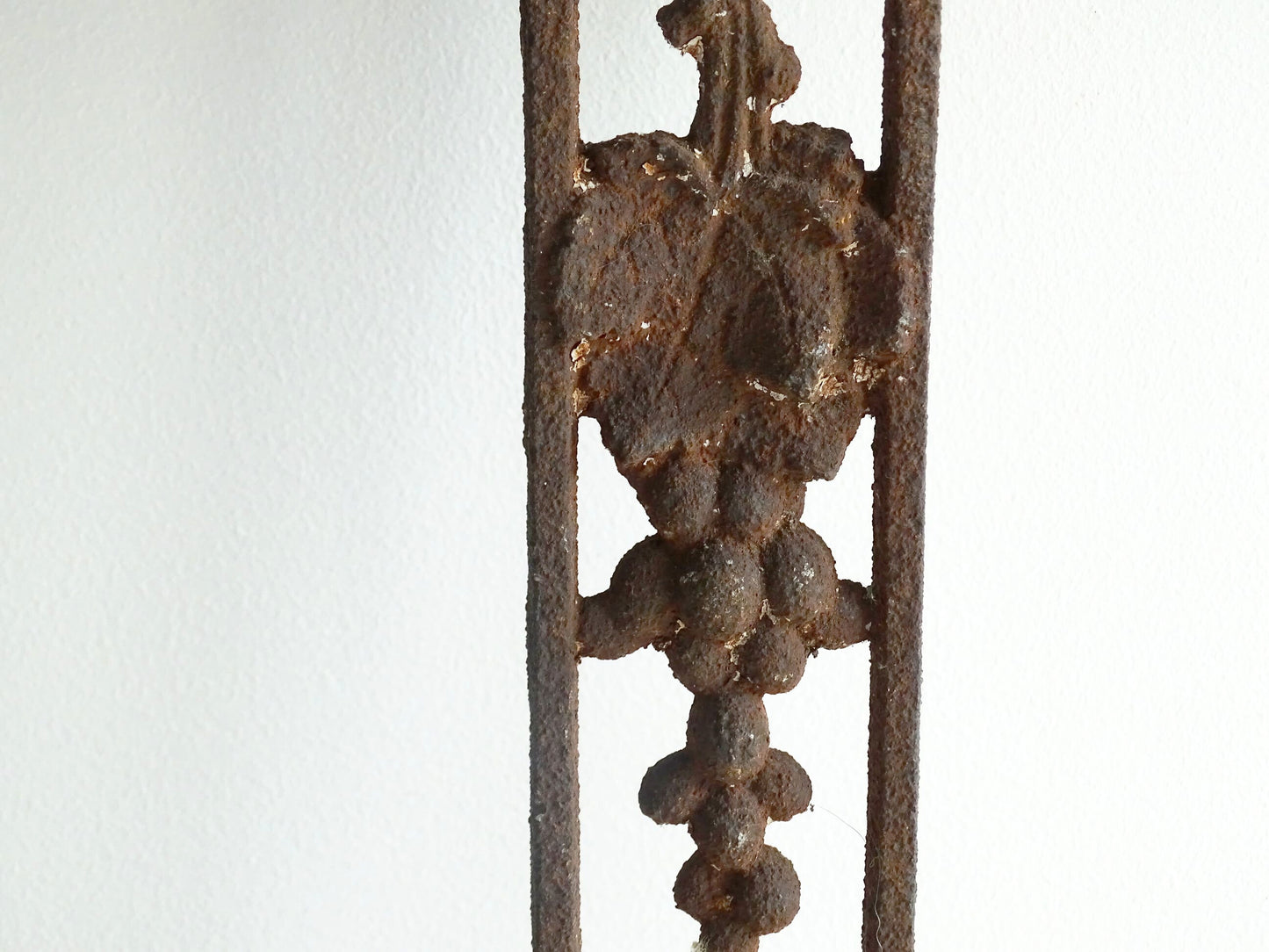 French antique cast iron field cross. Aged and rusted antique pilgrim cross decorated with grapes and vines.