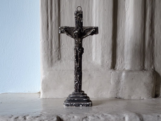 French antique standing cross in plaster, displayed on a country house fireplace