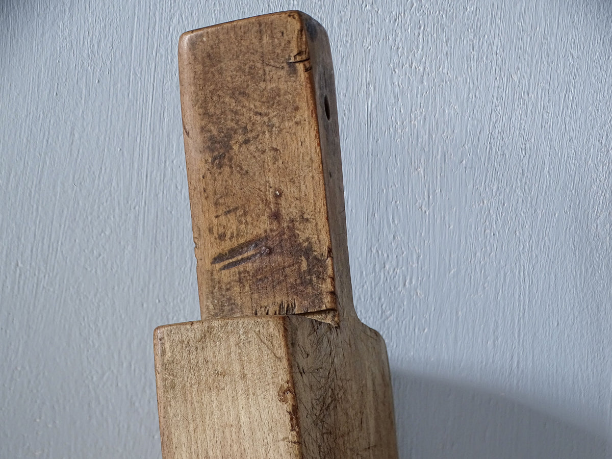 Close-up of old French wooden cutting board handle showing years of wear, scratches and darker areas of patina.