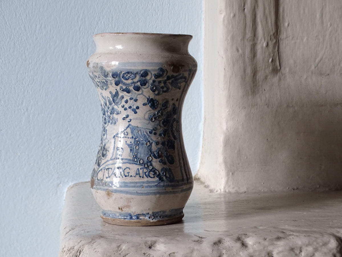 Antique Italian earthenware jar, a tin glazed alabrello from the 18th century, pictured on a French country fireplace