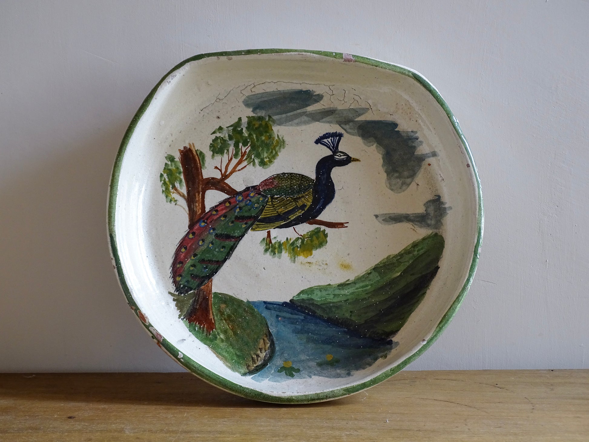 French antique glazed terracotta bowl, with hand-painted green highlights and a peacock motif to the centre. The pottery bowl is flat to the top, it is a decorative bowl for the coffee table or as wall decor.