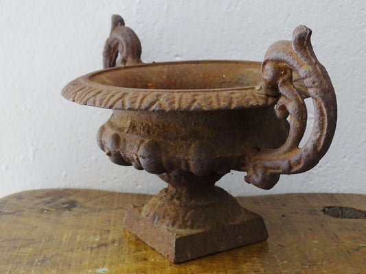 Antique French Medici cast iron urn planter or jardiniere with handles and rusted patina.