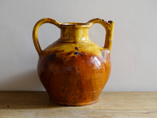 French antique pottery pitcher or orjol with golden caramel and yellow glaze. Antique terracotta cruche or jug with timeworn appearance.