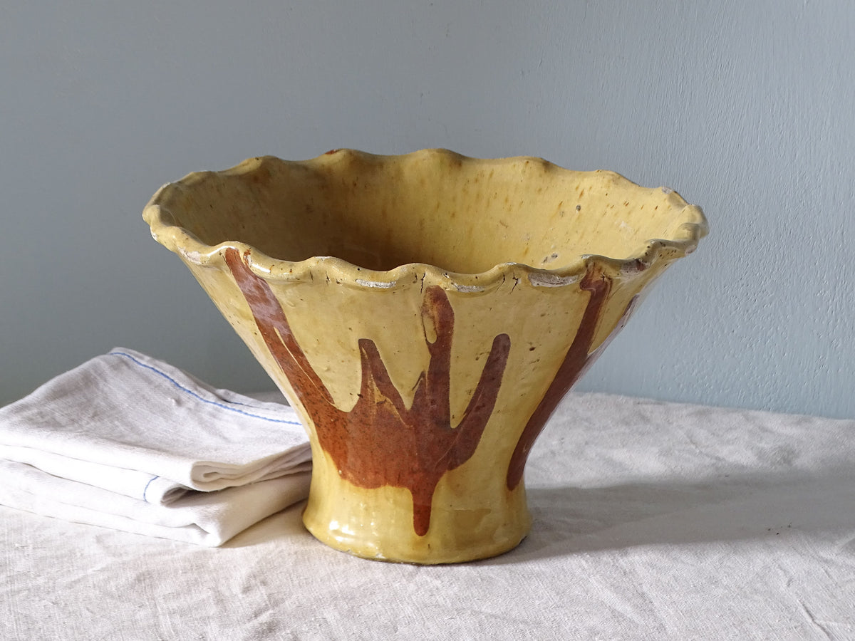 French antique earthenware bowl with yellow glaze, pictured with antique linen