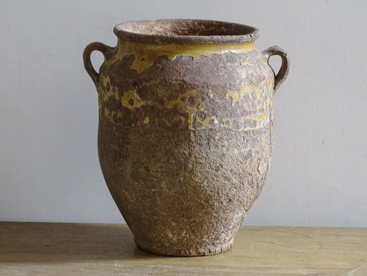 Rustic antique French confit pot with yellow glaze and coiled terracotta body