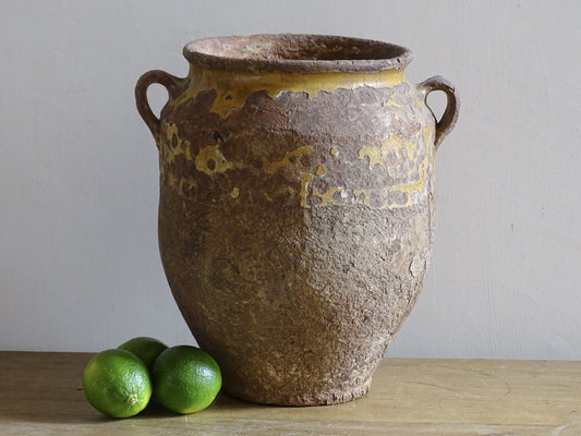 Rustic antique French confit pot with yellow glaze and coiled terracotta body