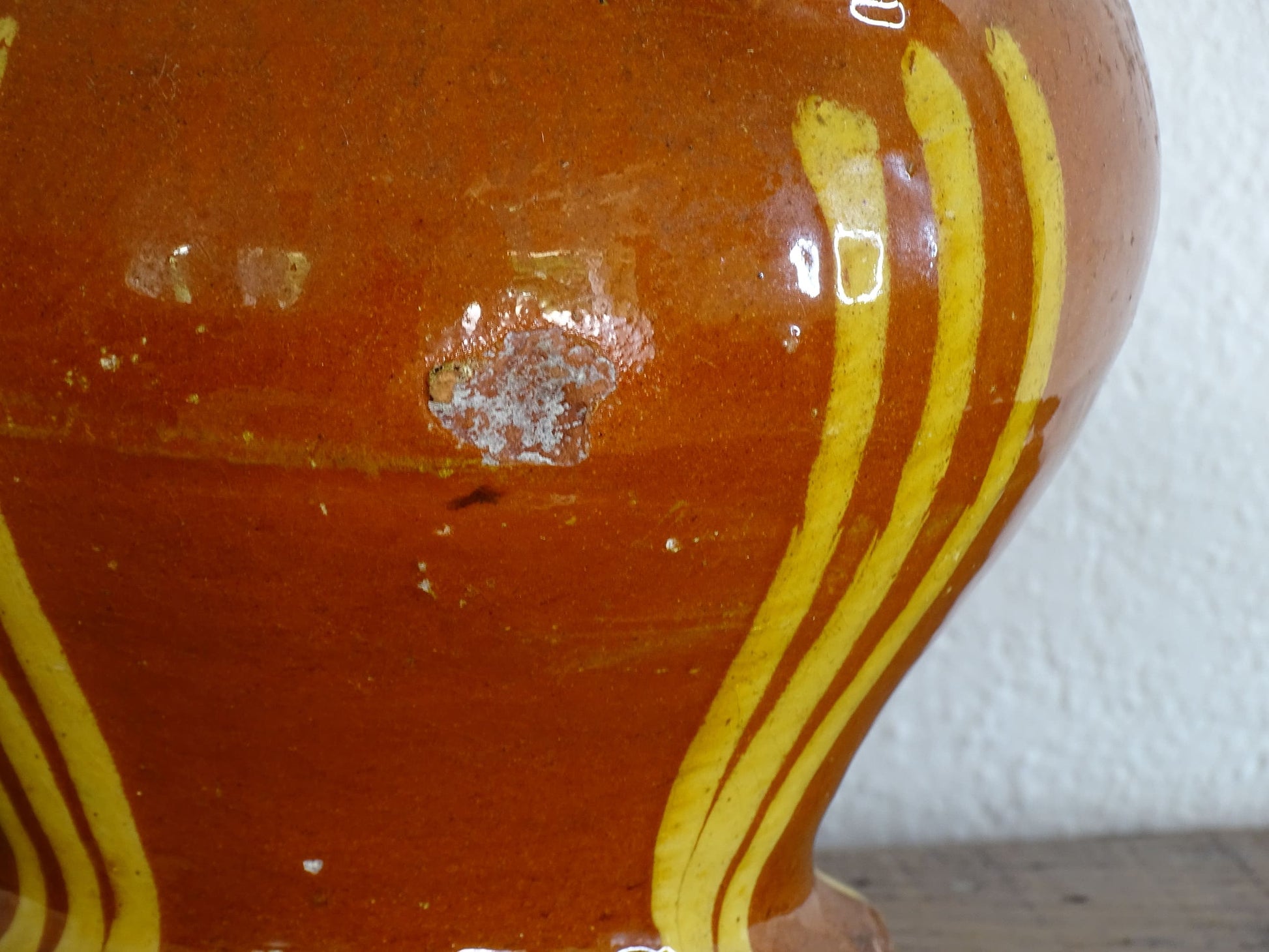 French antique pottery jug with russet glaze and yellow stripes. There is a handle to the top of this rustic terracotta earthenware pitcher and two spouts.