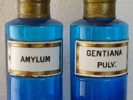 French antique blue glass apothecary bottles with brass tops. These pharmacy bottles or medicine bottles have porcelain labels.